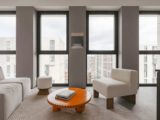 Modern living room with windows and neutral colors.